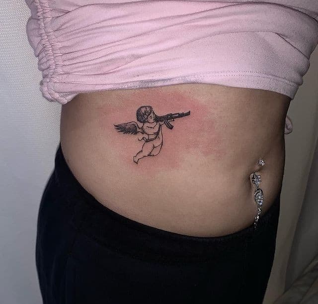 9] Belly Angel With Gun Tattoo for Women: Feminine and Empowering Tattoo