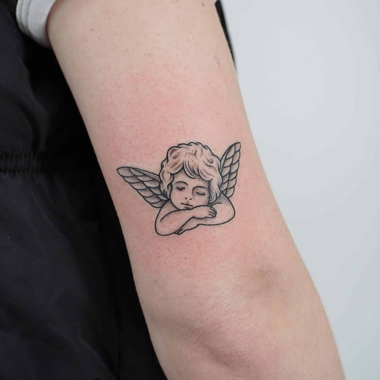 20] Sleeping Cherub Elbow Tattoo: Dreamy Slumber