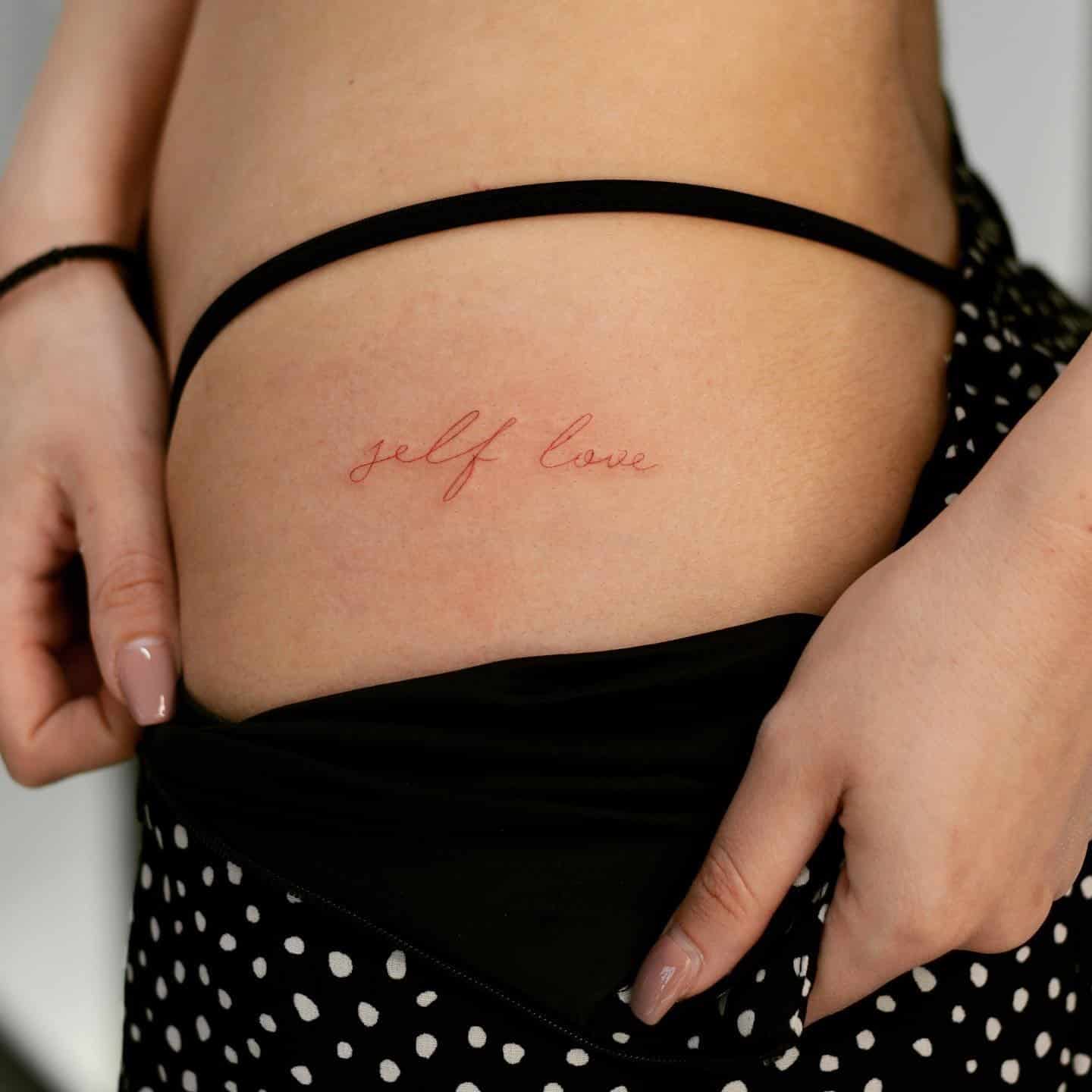 2] ‘Self Love’ Red Text Tattoo on Hip: Radiant Self-Love