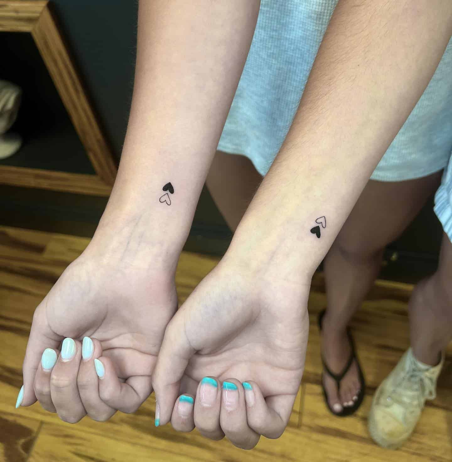 56] Sisterly Love: Matching Heart Tattoos on Wrists