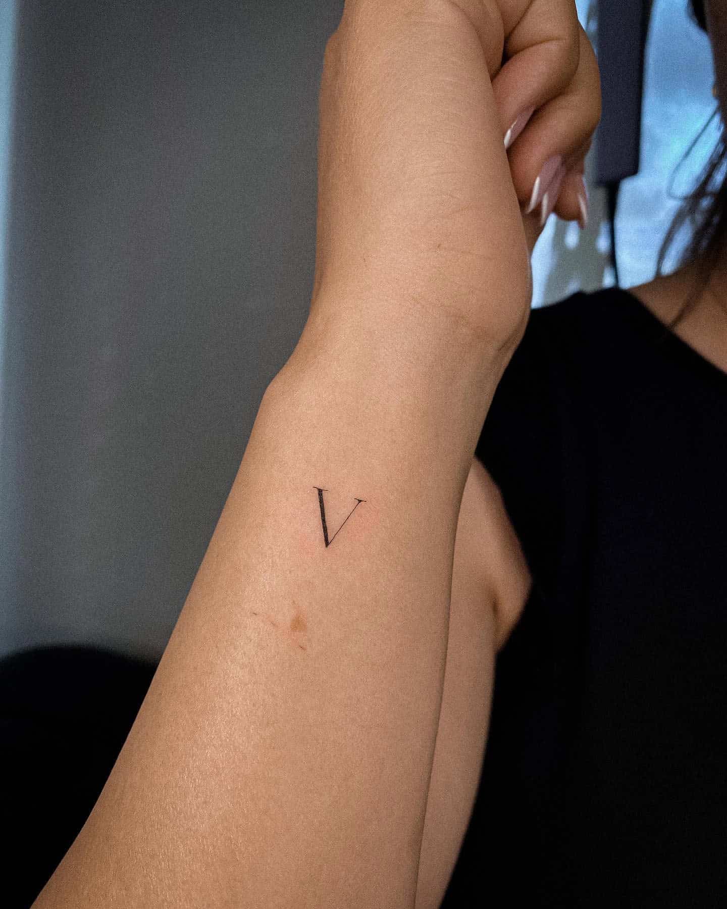 44] Side Wrist Letter ‘V’ Tattoo: Feminine Touch