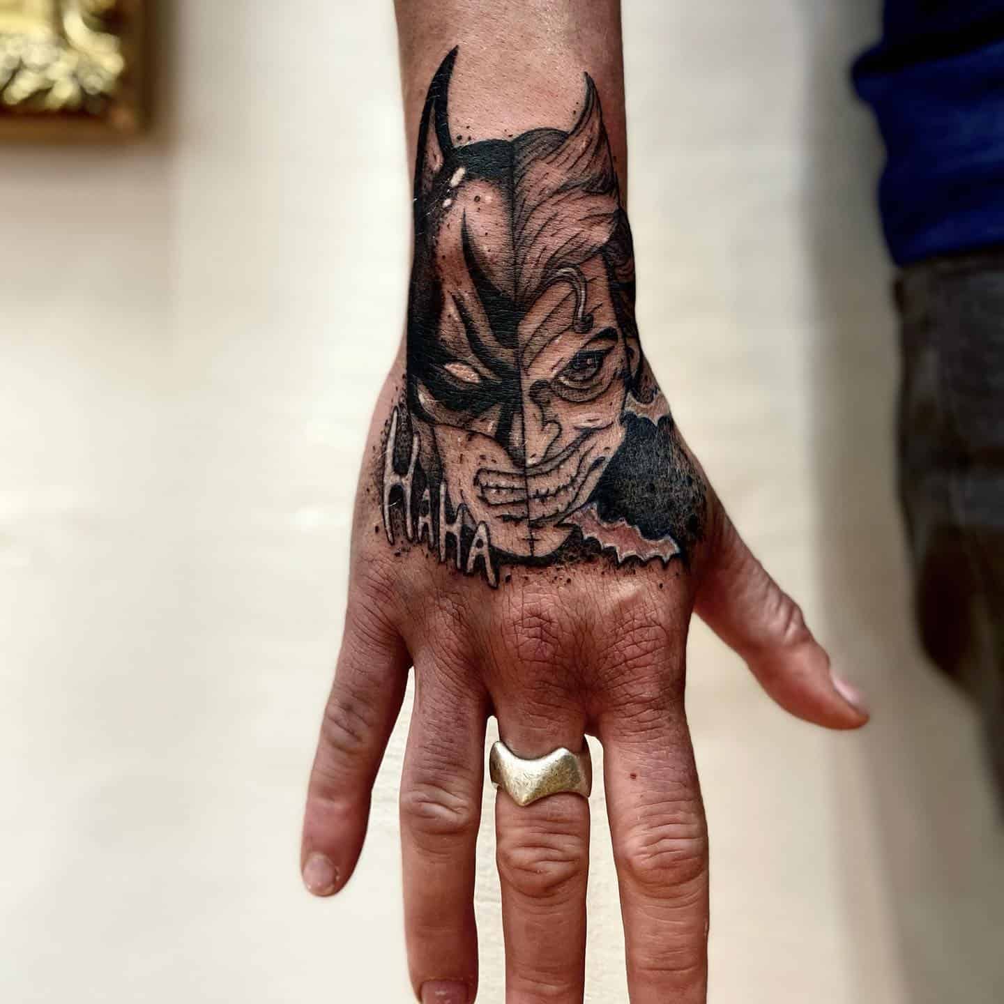 12] Batman/Joker Hand Cover-up Tattoo with “Hahaha” Text