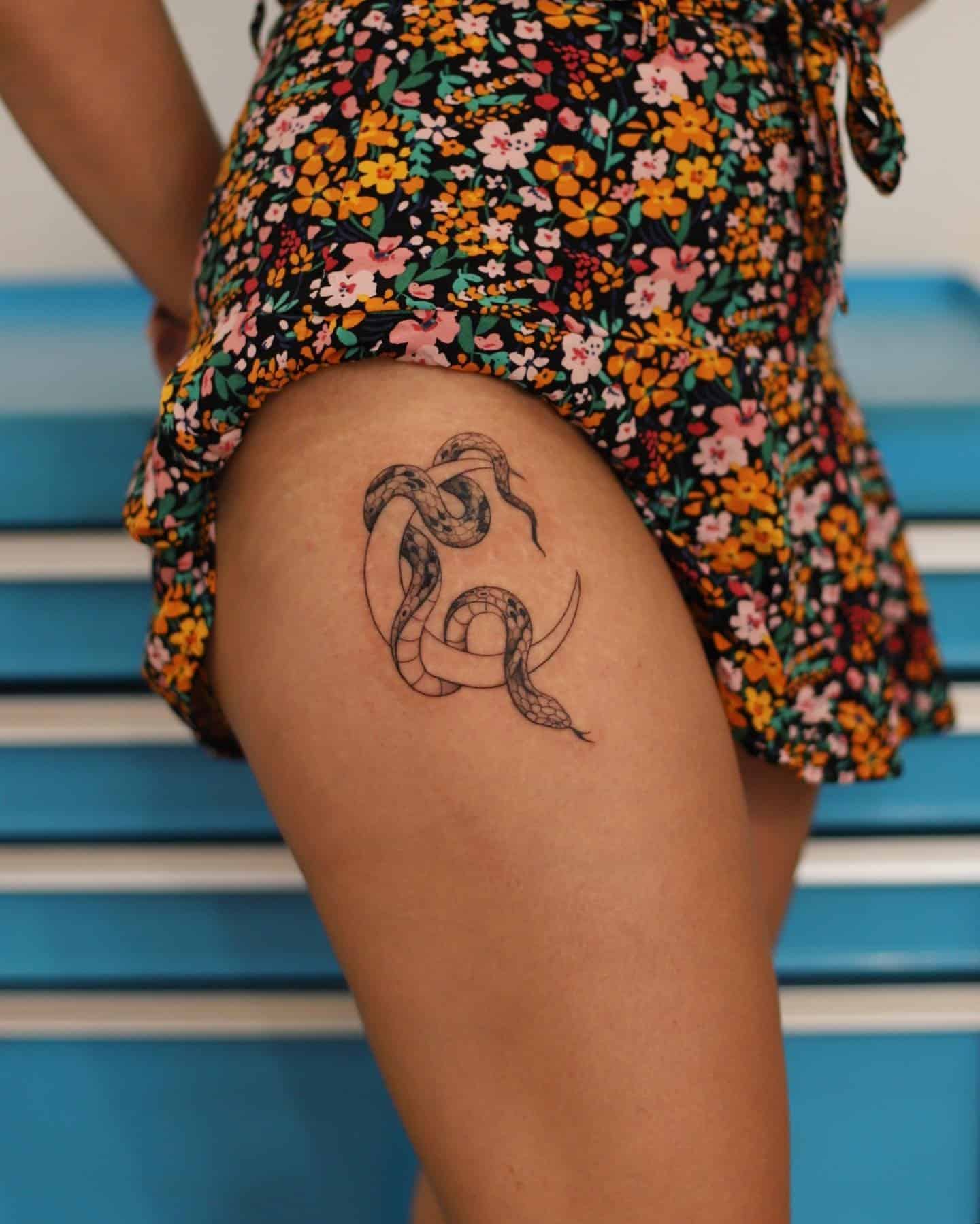 32] Snake and Moon Hip Tattoo: Celestial Embrace