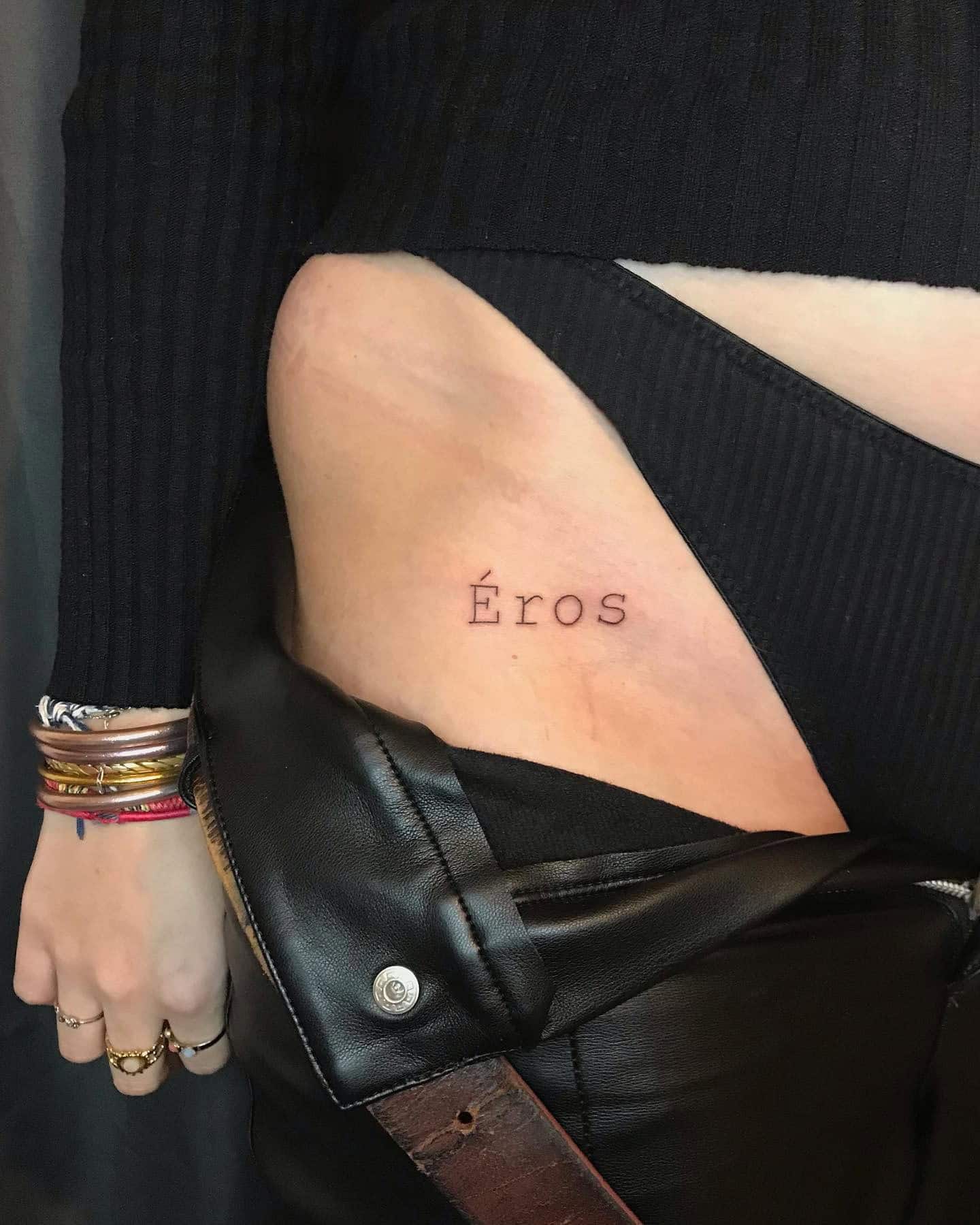 39] ‘Éros’ Artistic Script Hip Tattoo: Passion Expression