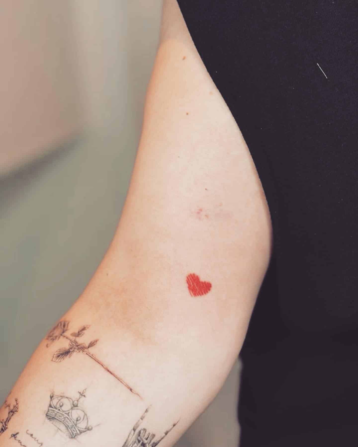 52] Red Bicep Heart Tattoo: Vibrant Femininity