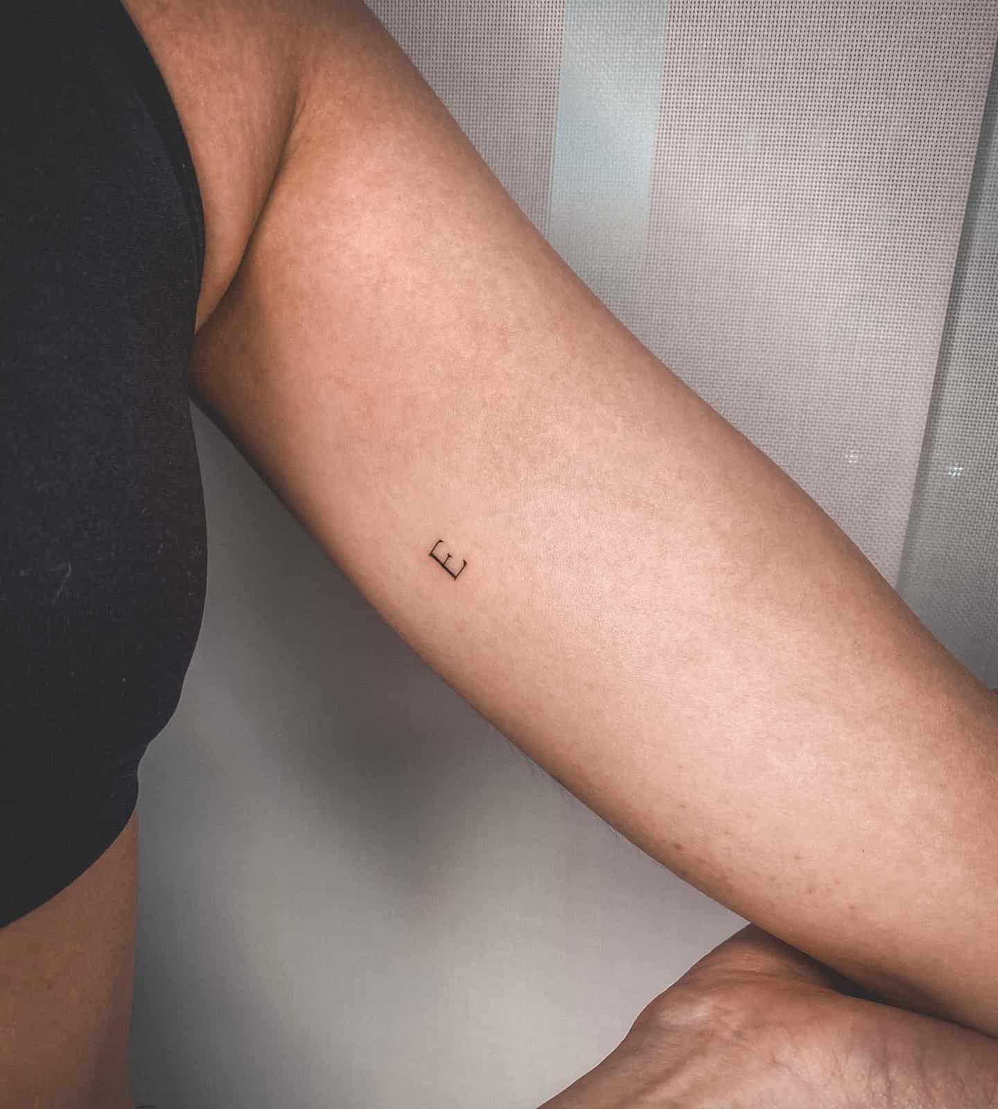 47] Feminine ‘E’ Letter Tattoo: Bicep Beauty