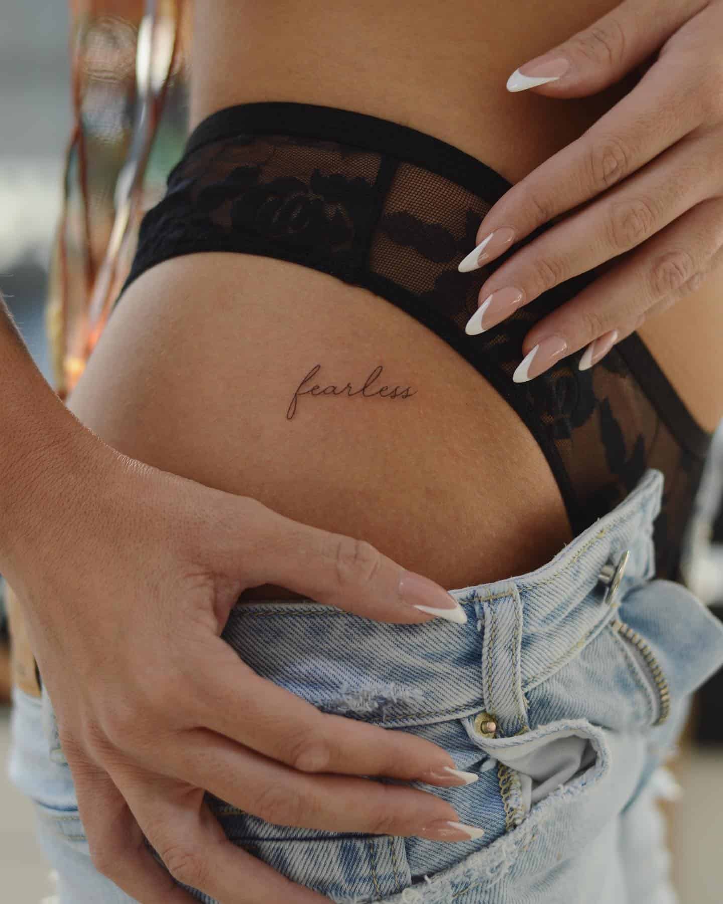 14] ‘Fearless’ Bold Text Hip Tattoo: Fearless Expression