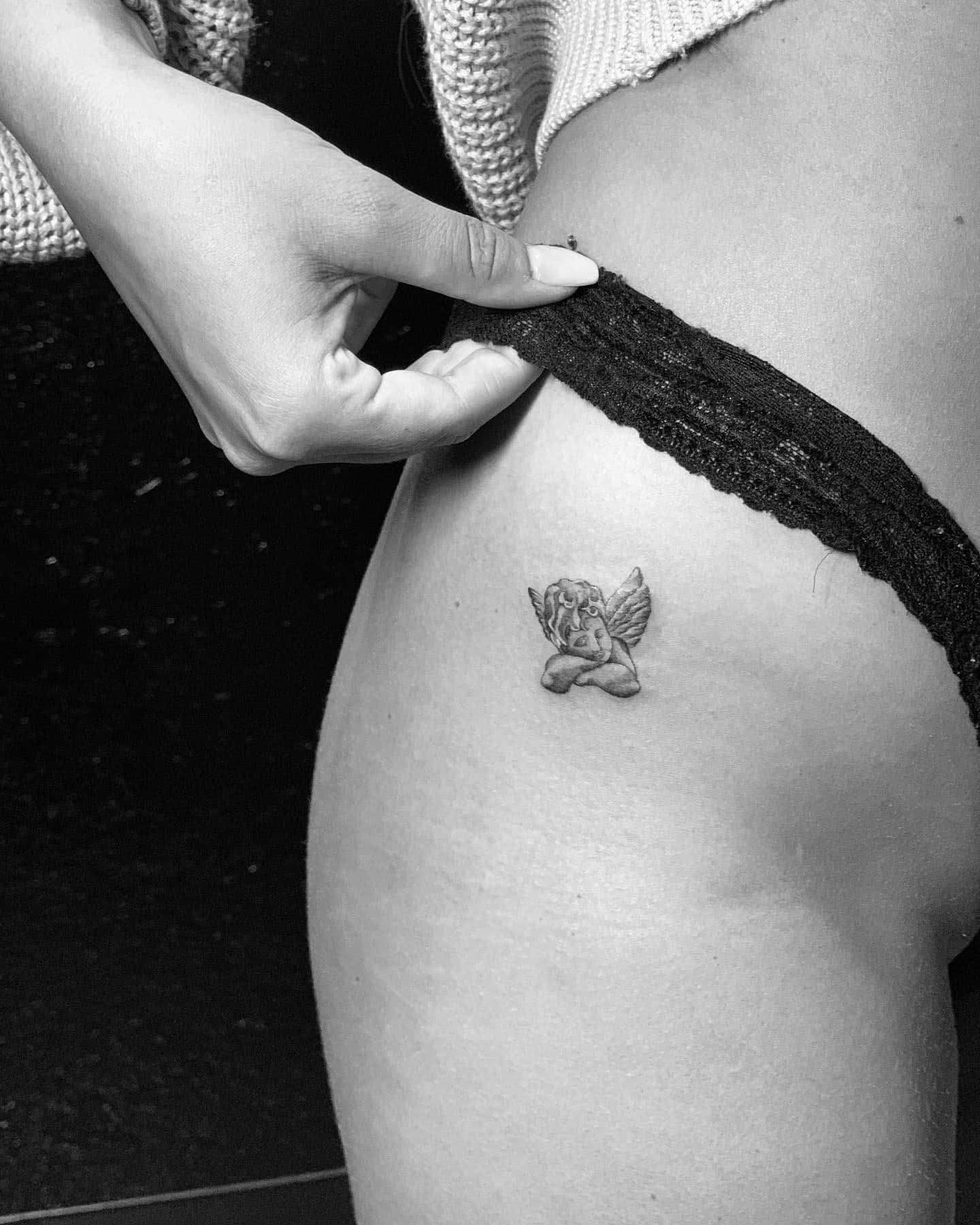 23] Sleepy Baby Angel Hip Tattoo: Minimalistic Slumber