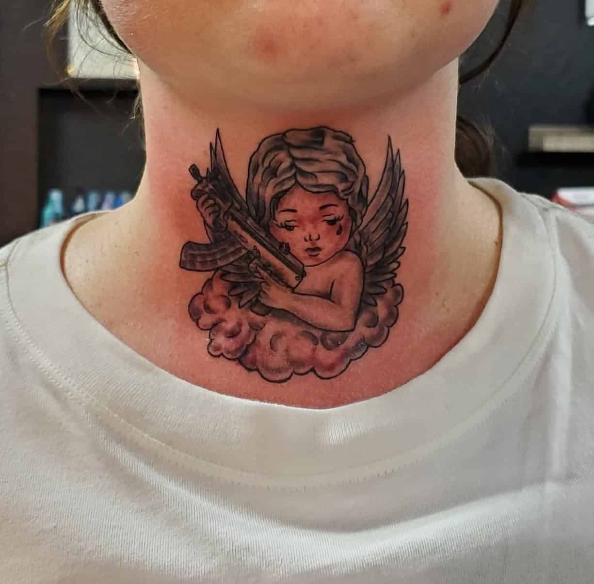 2] Front Neck Angel With Gun Tattoo: Unique Placement Inspiration